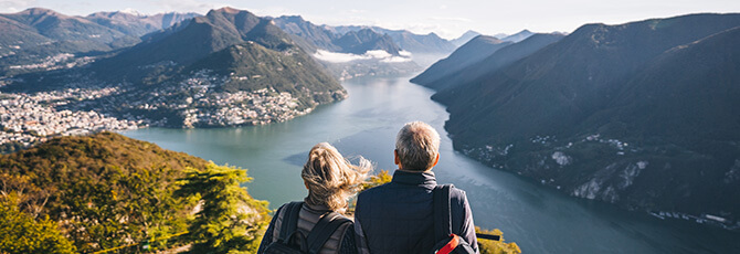 Mature couple hike above lake Lugano in the morning